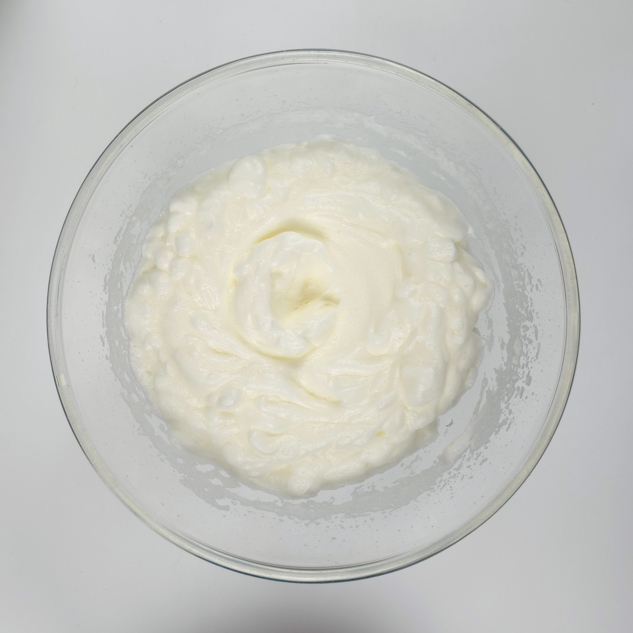 beaten egg whites in a glass bowl