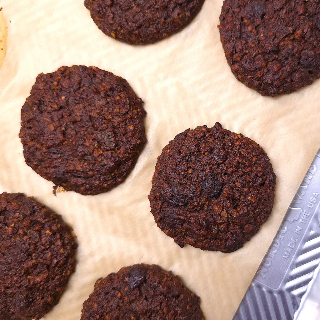 a baking tray with flourless hazelnut chocolate cookies on parchment paper