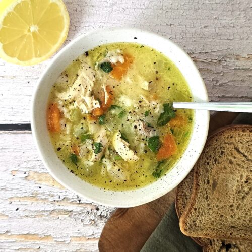 Comforting gluten-free chicken soup ready to serve with fresh parsley and side of toasted gluten-free bread