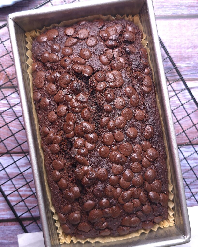 a baking pan with gluten-free chocolate banana bread on a cooling rack