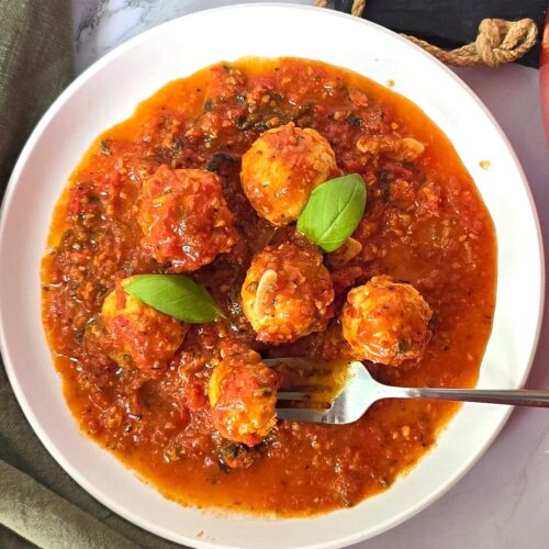 chicken meatballs in marinara sauce in white ceramic plate
