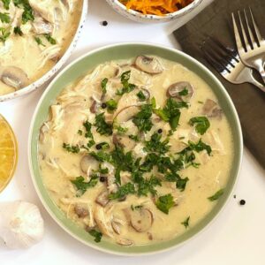 chicken fricassee with mushrooms in a green plate