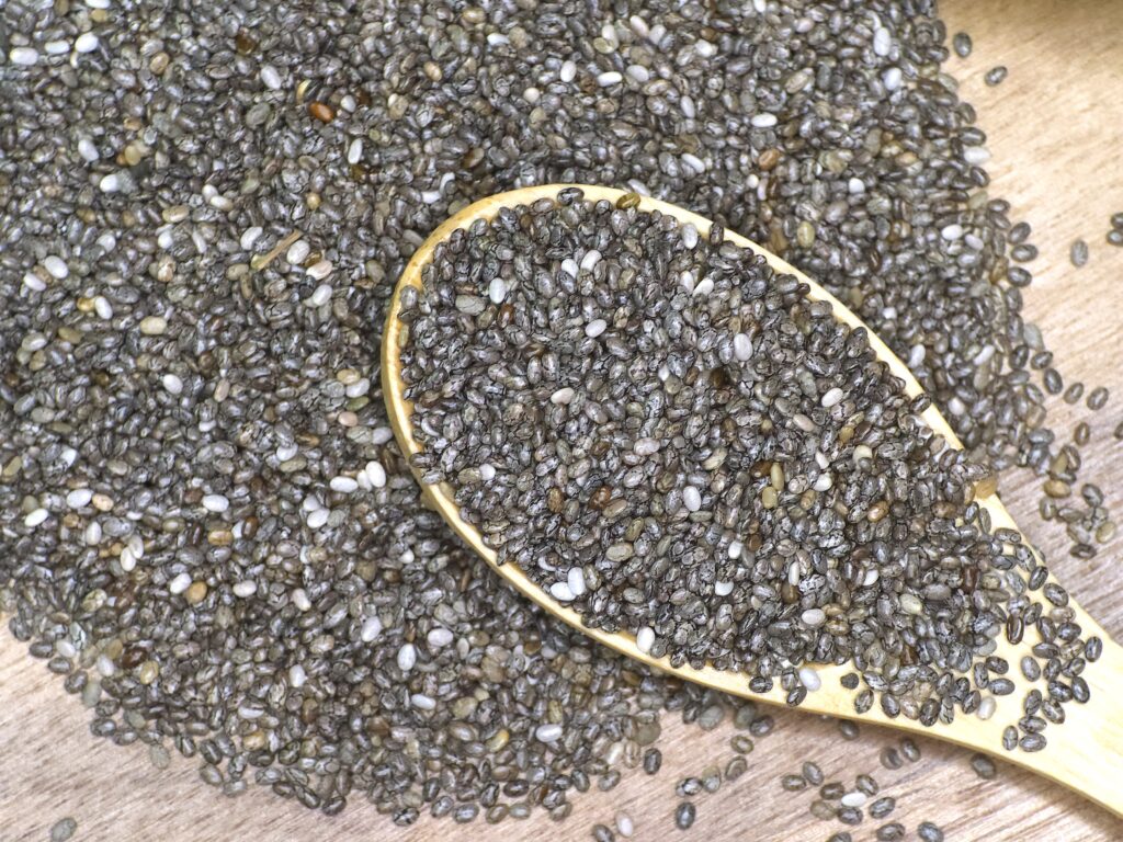 chia seeds spilled on a surface and wooden spoon