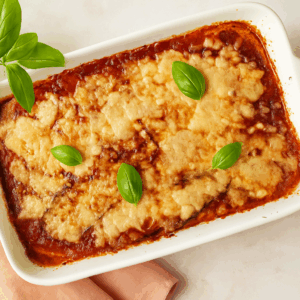 Aubergine parmigiana baked in white ceramic dish