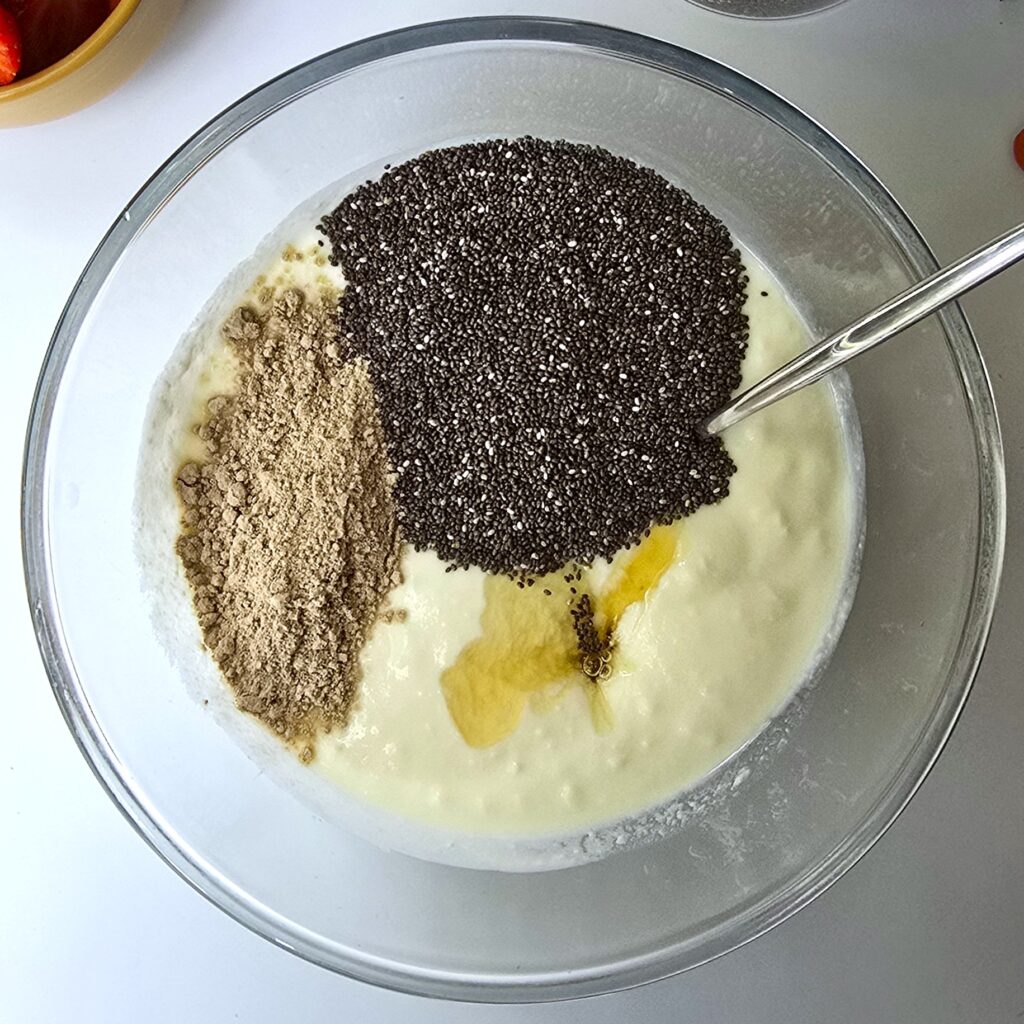 a large glass mixing bowl with yoghurt, chia seeds, psyllium husk and honey before blending