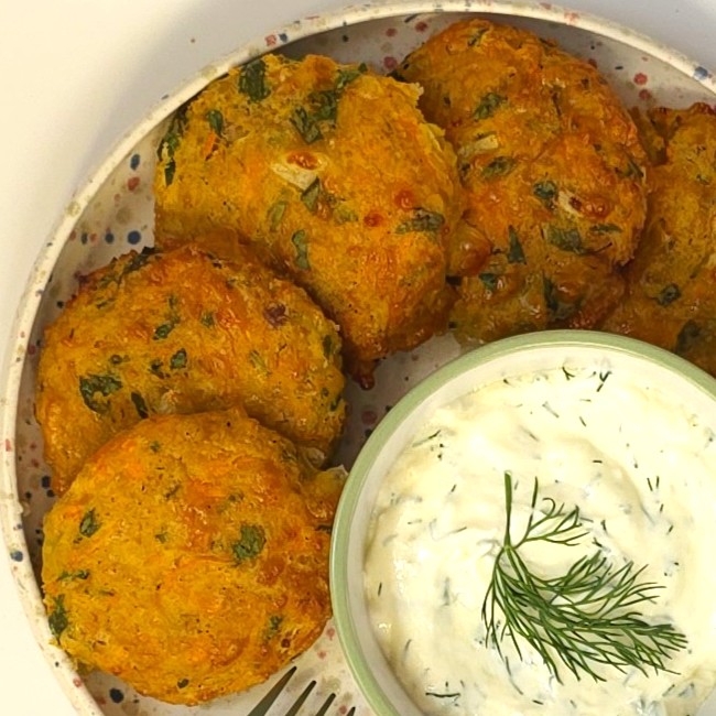 chickpea patties in a plate next to yogurt garlic sauce