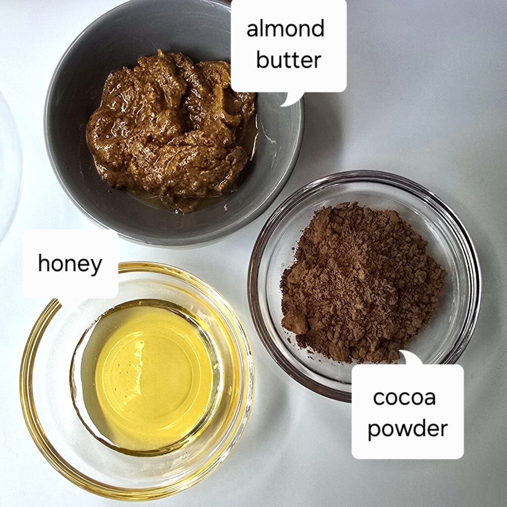 chocolate ganache ingredients - almond butter, cocoa powder and honey in bowls