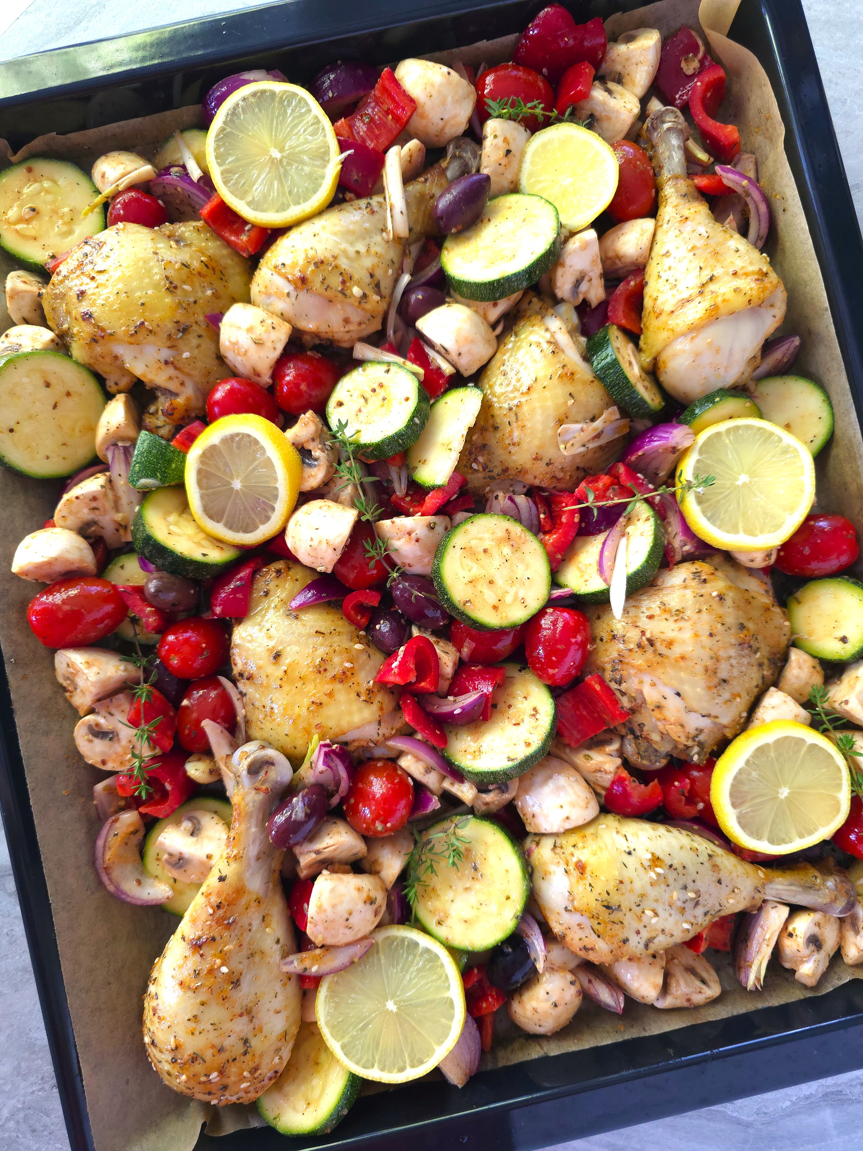 Greek chicken sheet pan all ingredients in a baking tray, ready for the final roast