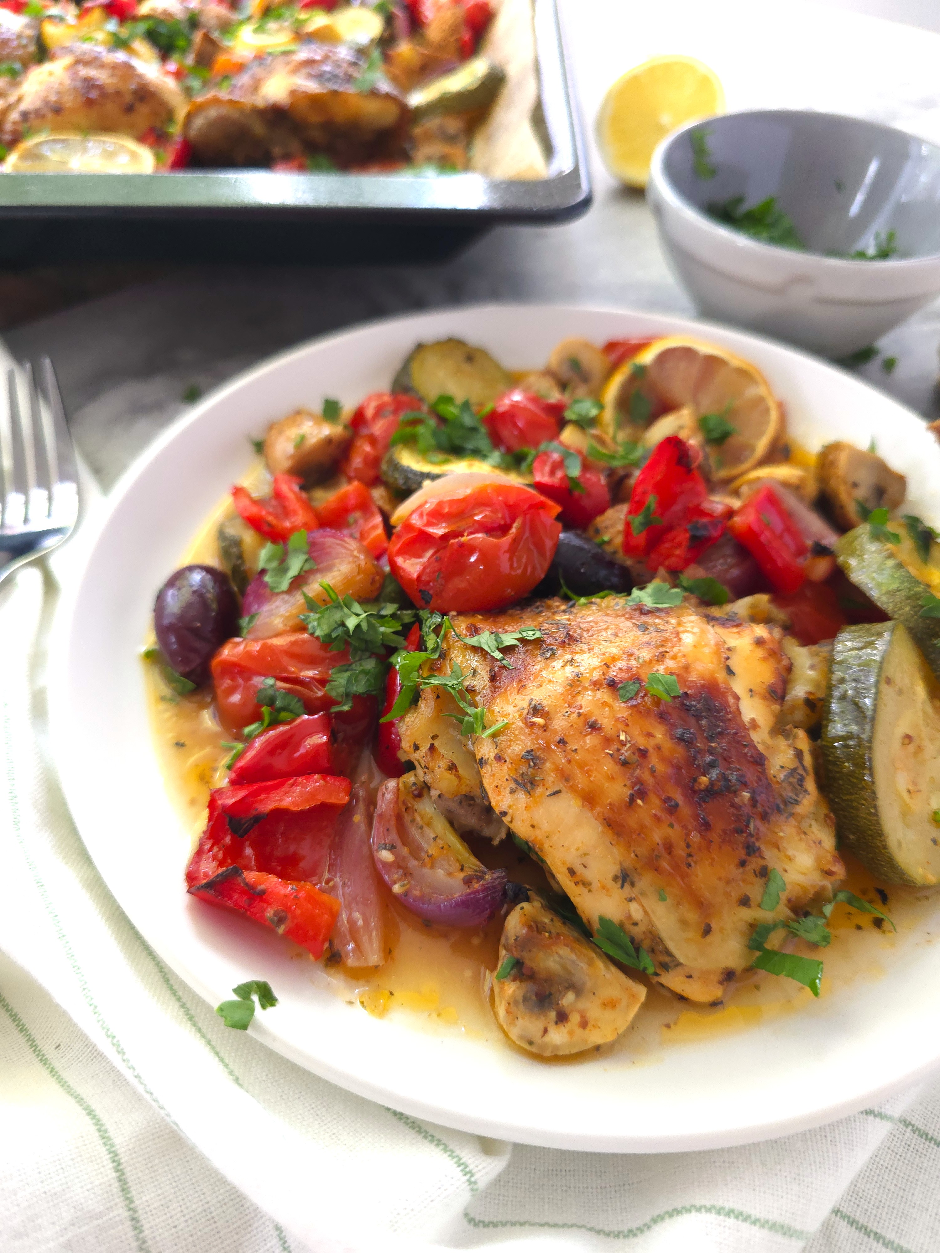 greek chicken sheet pan portion in a white plate