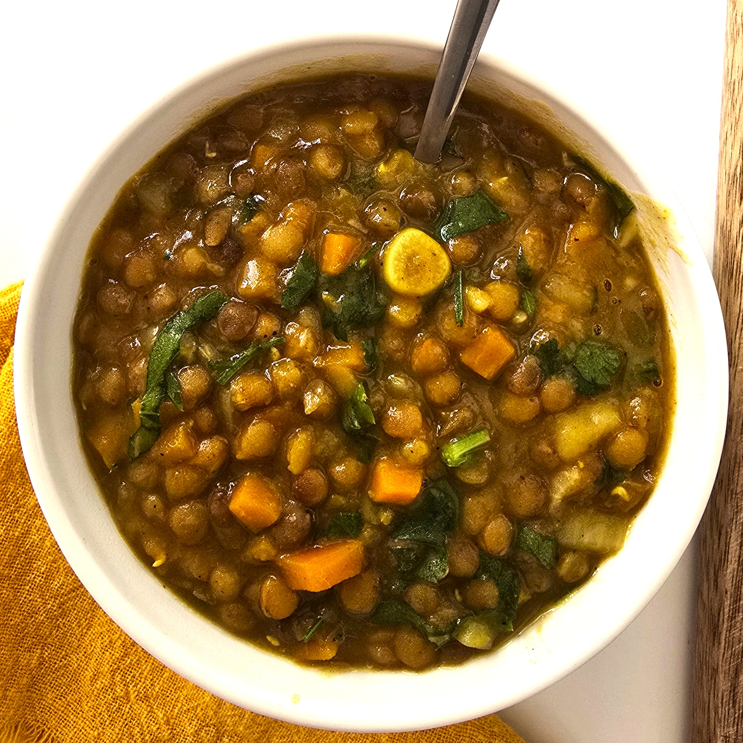 lentil soup in a white bowl and spoon