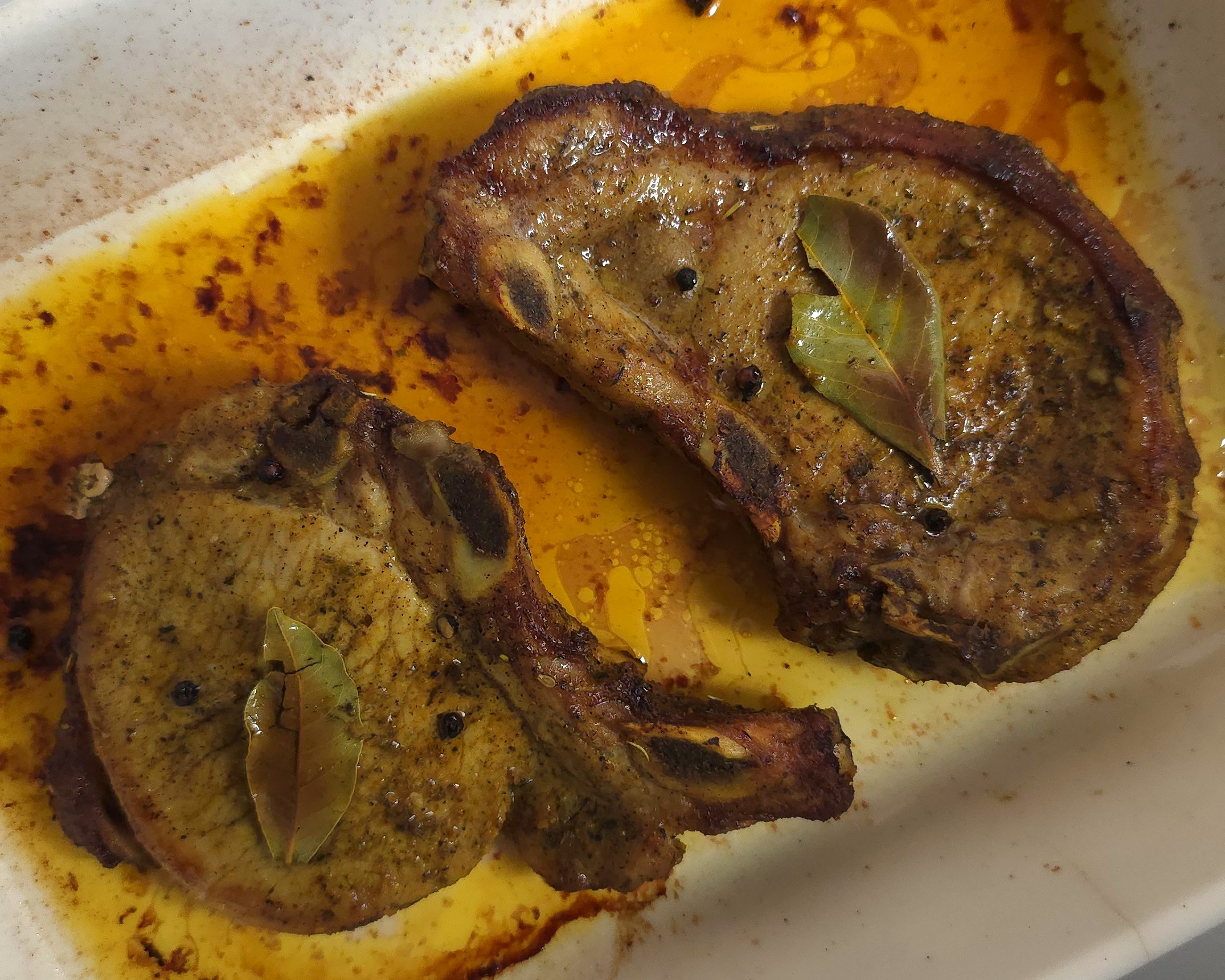 roasted pork chops in a white ceramic roasting tray