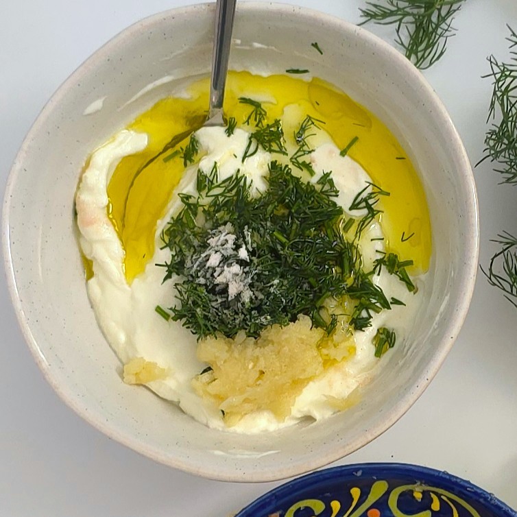 yoghurt garlic sauce ingredients in a white bowl ready for mixing