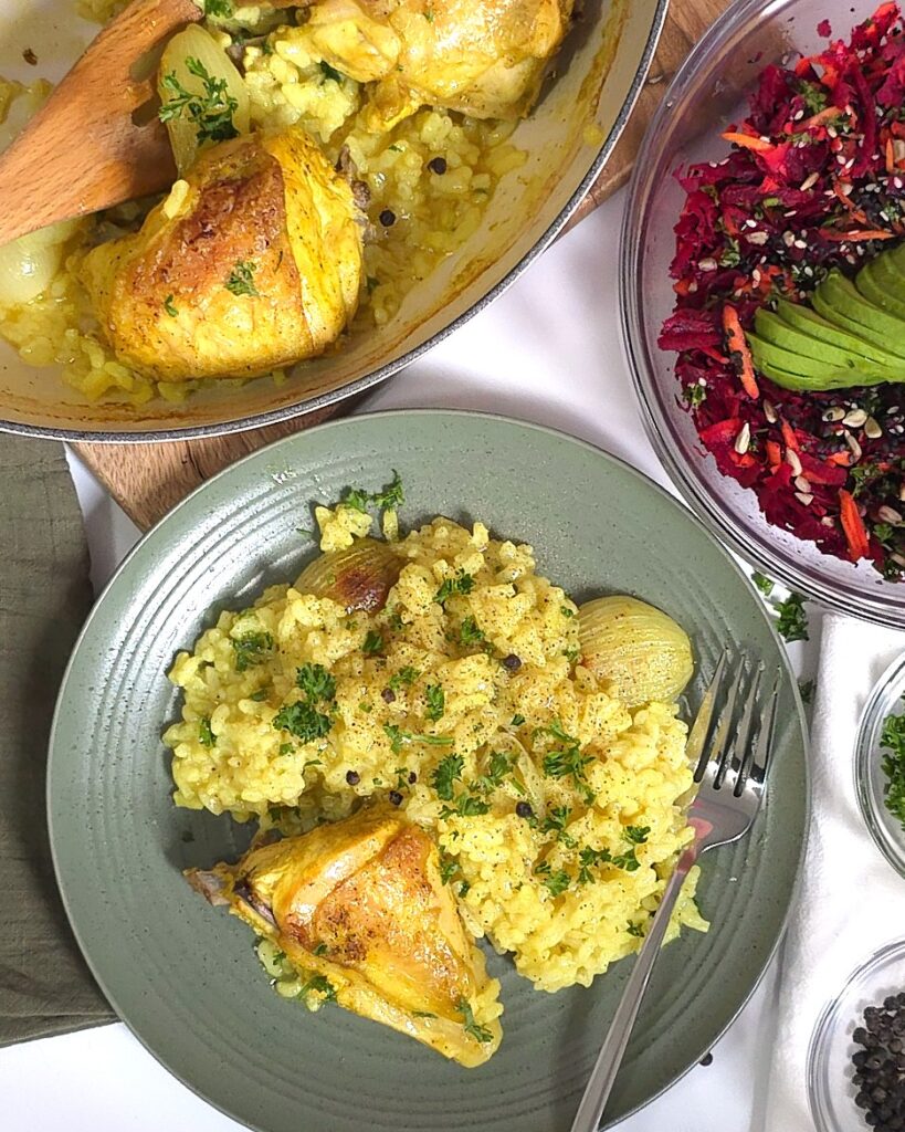 chicken with rice in a plate next to beetroot carrot salad