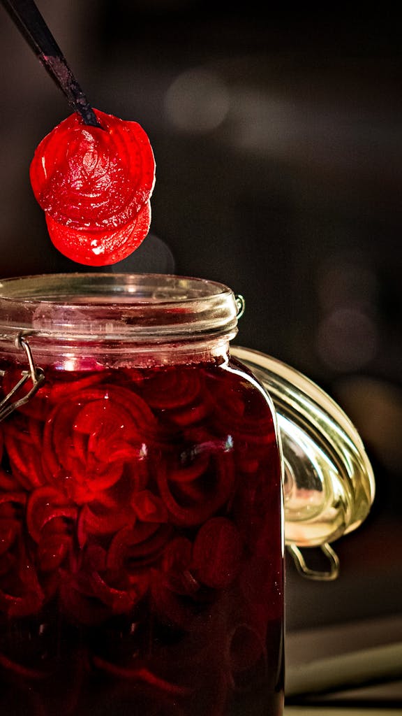 Close-up of sliced red beets in a jar, highlighting vibrant color and preserving technique.