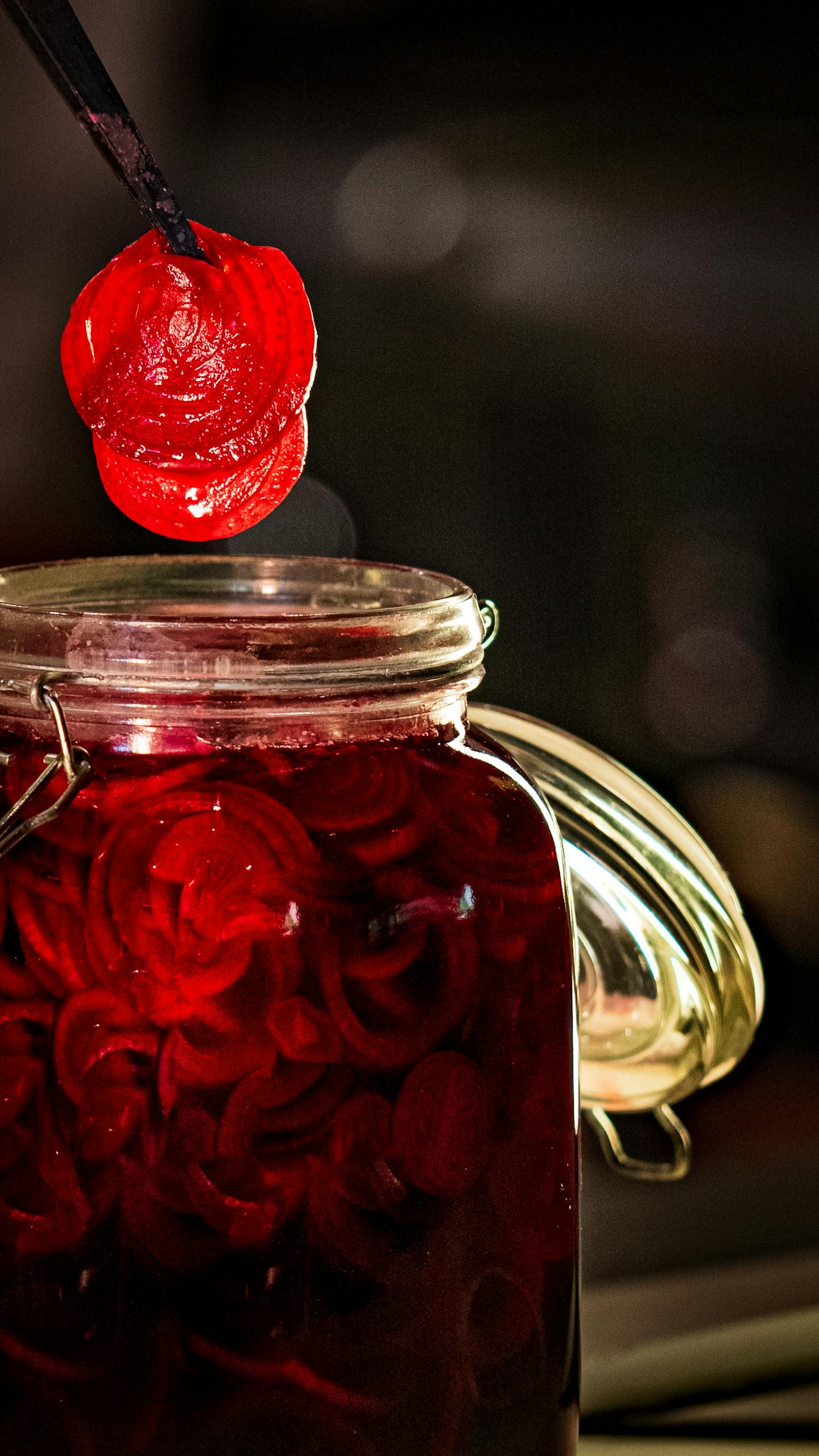Close-up of sliced red beets in a jar, highlighting vibrant color and preserving technique.