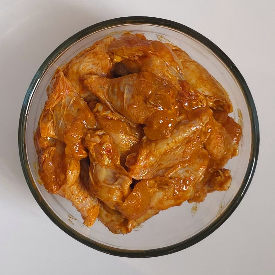 marinated chicken wings in a glass bowl