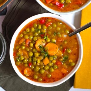 a white rustic bowl with a pea stew on a linnen napkin