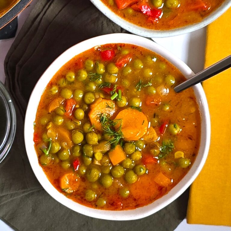 a white rustic bowl with a pea stew on a linnen napkin