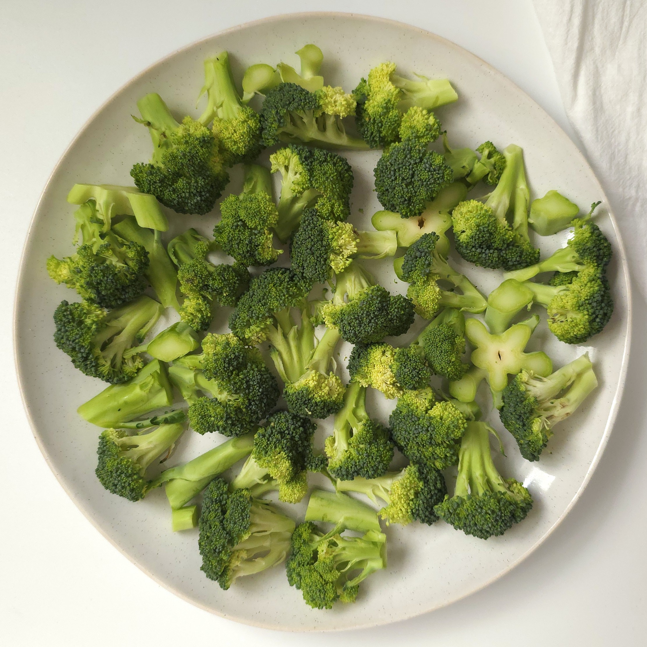 raw broccoli in a white plate