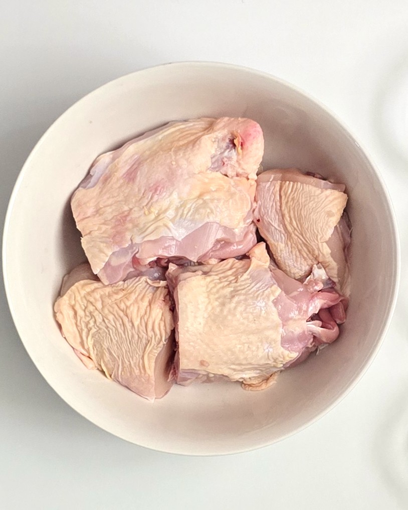 a bowl with a raw uncooked chicken