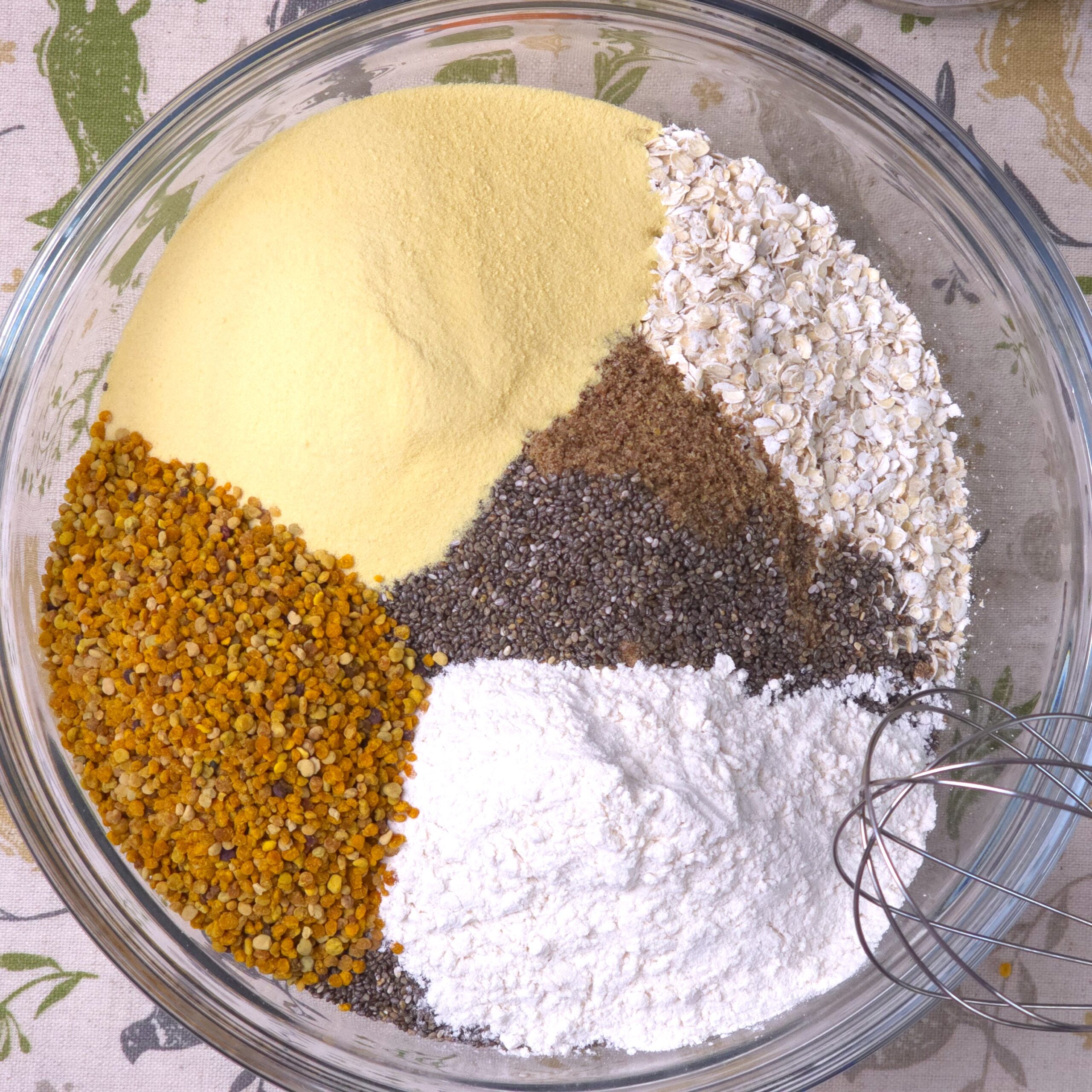 a glass bowl with gluten-free oats, chia seeds, flaxseeds, inulin powder, bee pollen and pectin - ingredients for a fibre-rich breakfast mix