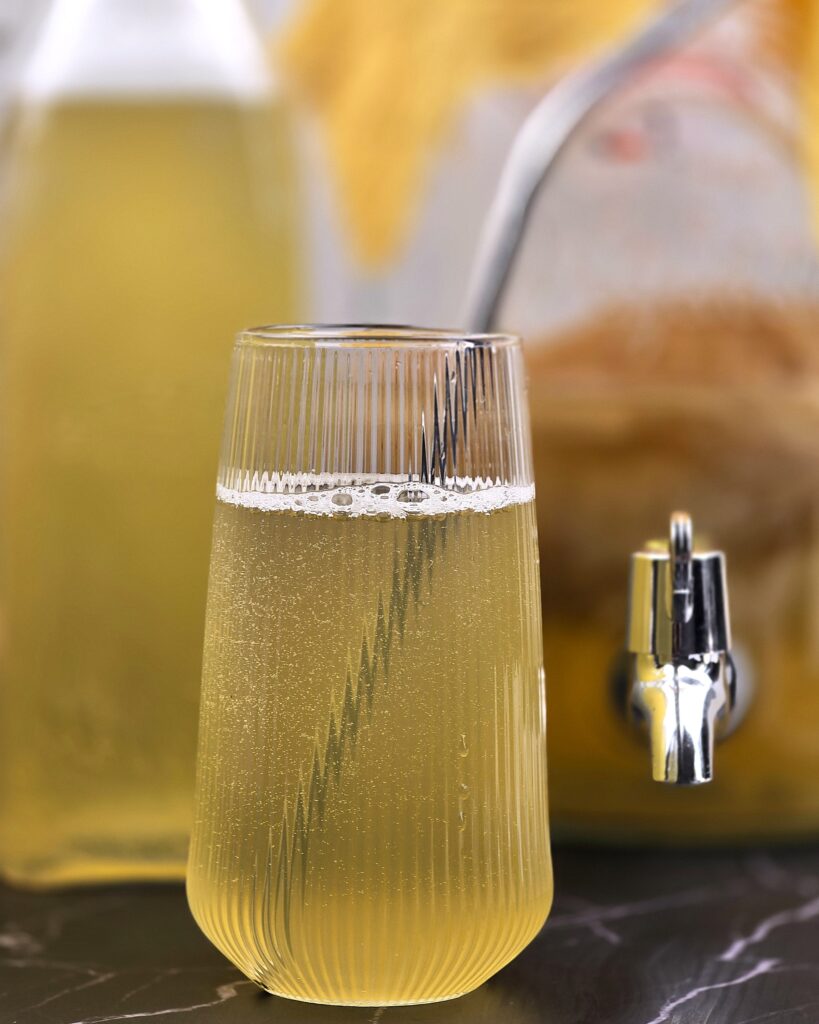 a glass with first fermented kombucha with a straw
