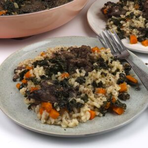 a green stoneware plate with chicken liver rice with vegetables