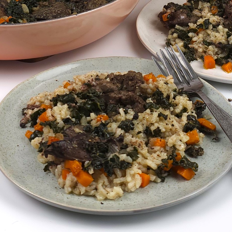 a green stoneware plate with chicken liver rice with vegetables