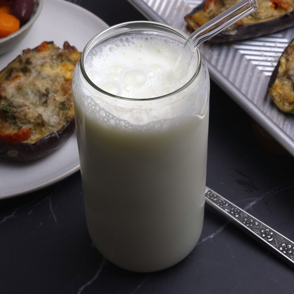 a glass with fresh ayran probiotic drink and glass straw