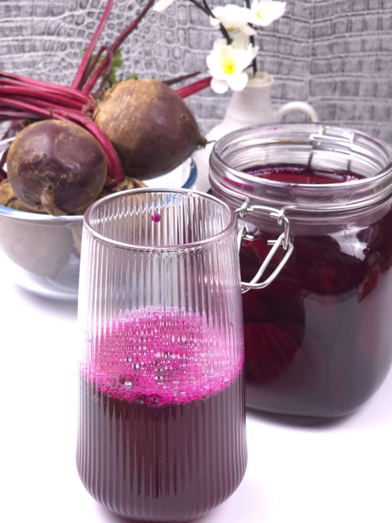 beetroot kvass in a glass, beetroot kvass in a jar next to a bowl with beets