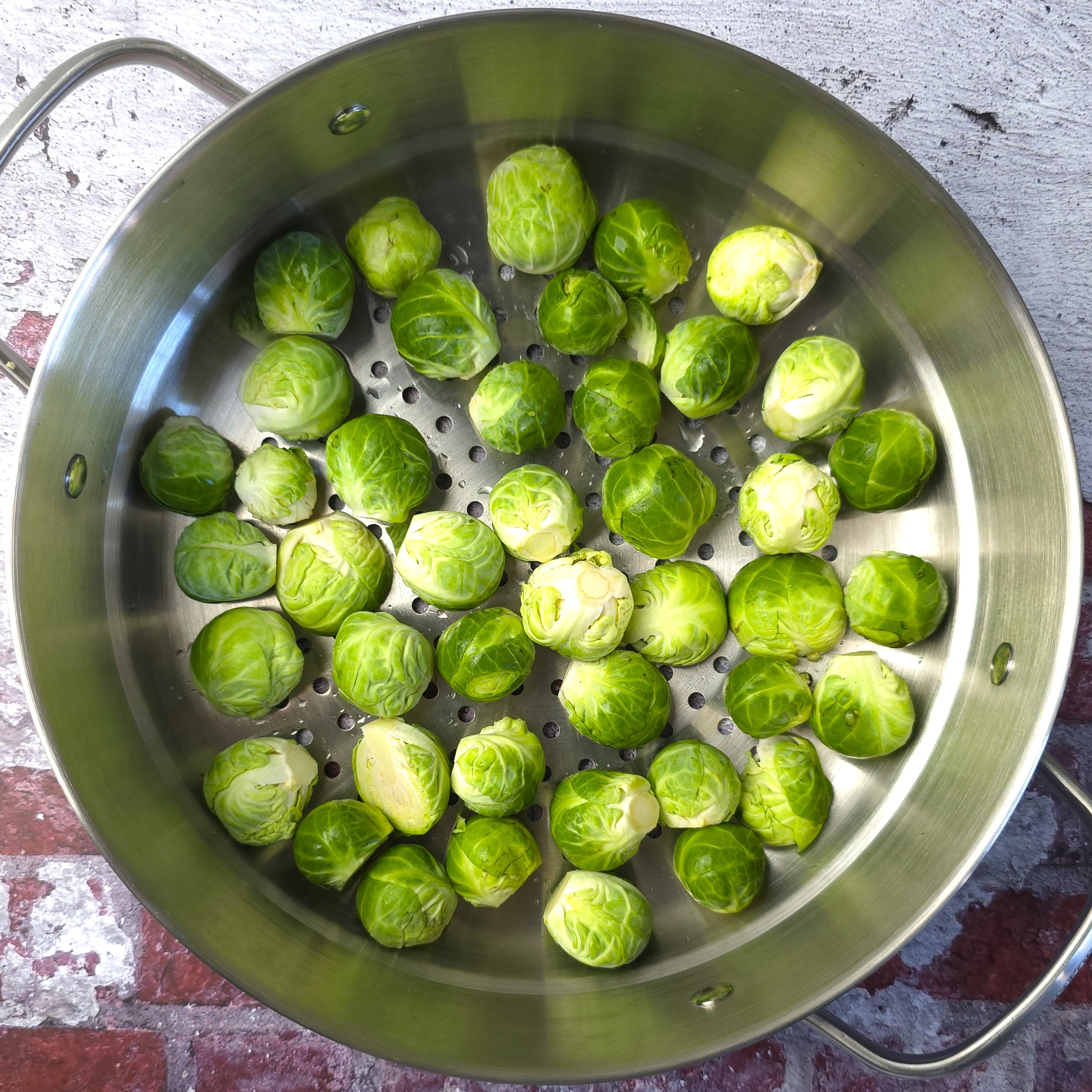 uncooked brussels sprouts in a steaming basket