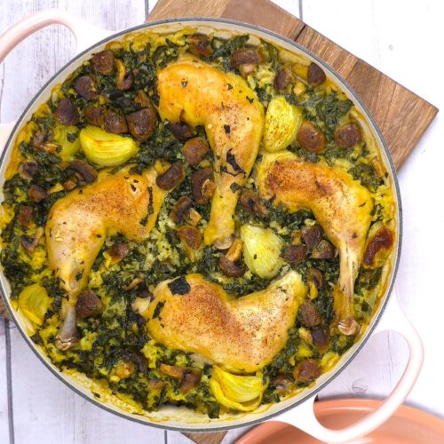 a cast iron baking shallow dish with cooked chicken, rice and kale recipe