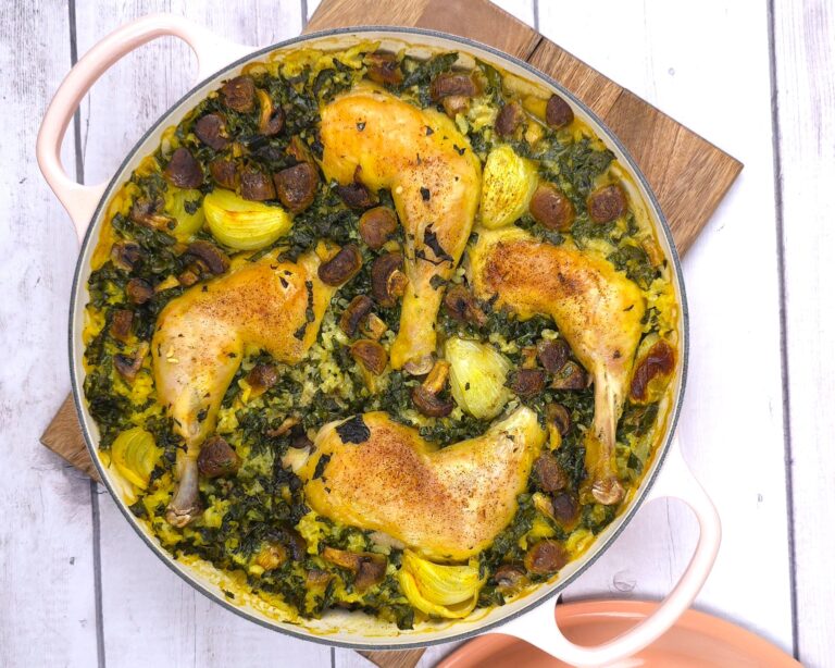 a cast iron baking shallow dish with cooked chicken, rice and kale recipe