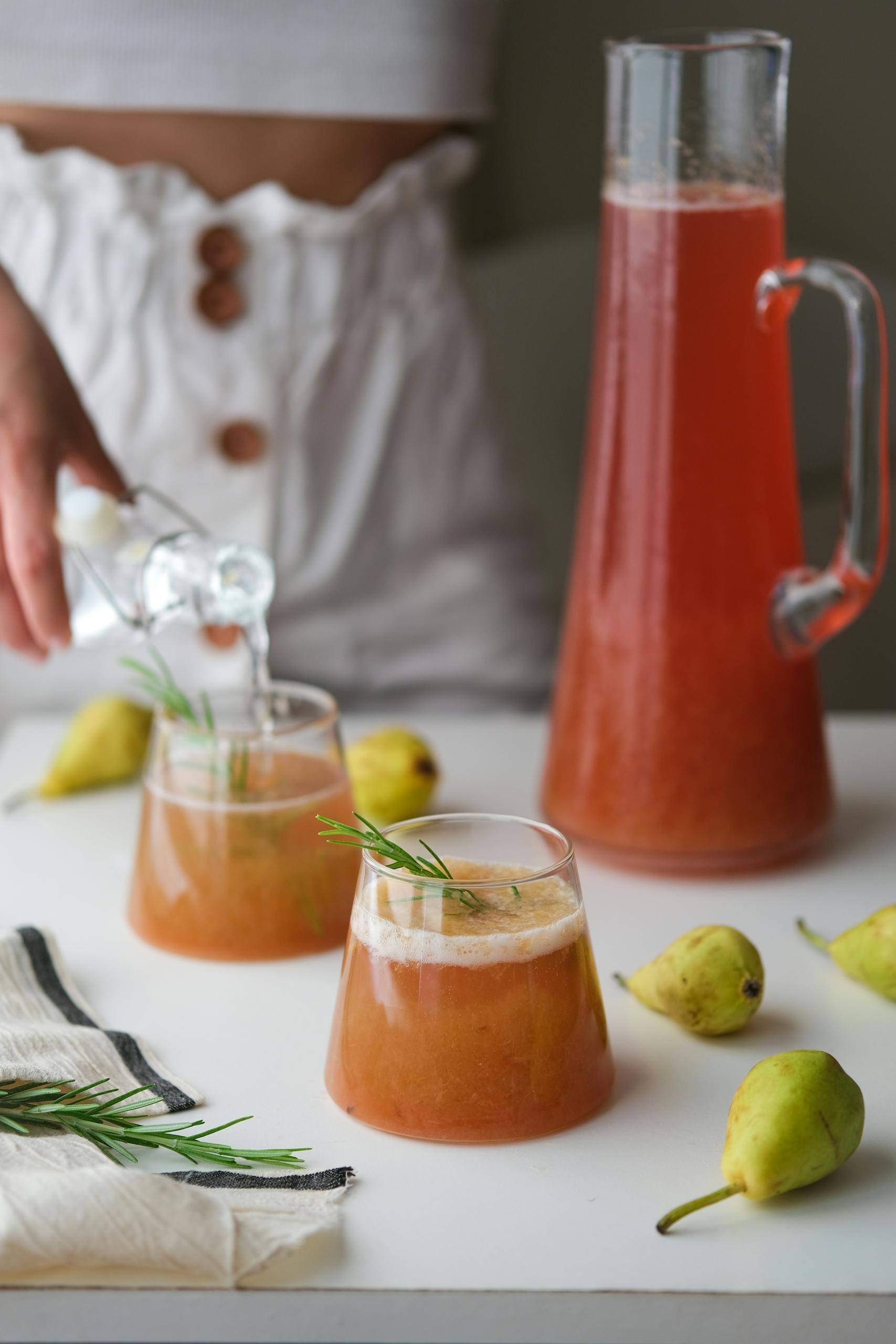 Delight in a fresh pear and rosemary vegan juice, elegantly served for a healthy sip.