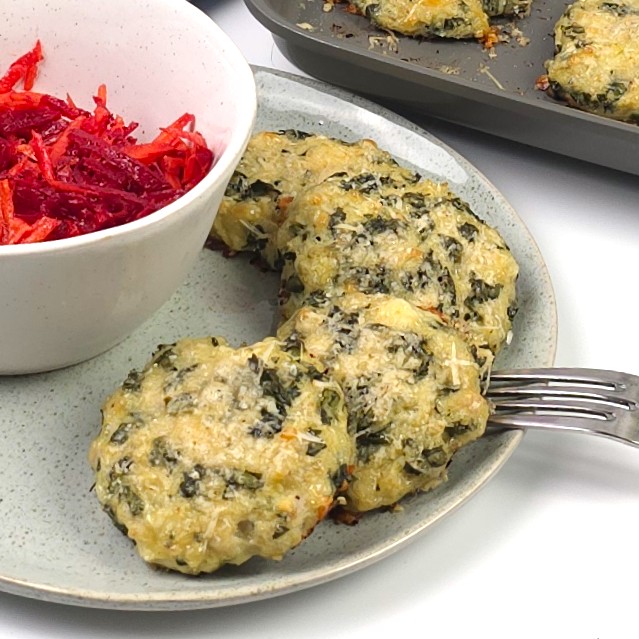 turkey kale cheesy patties in a green stoneware plate next to a bowl with beetroot salad