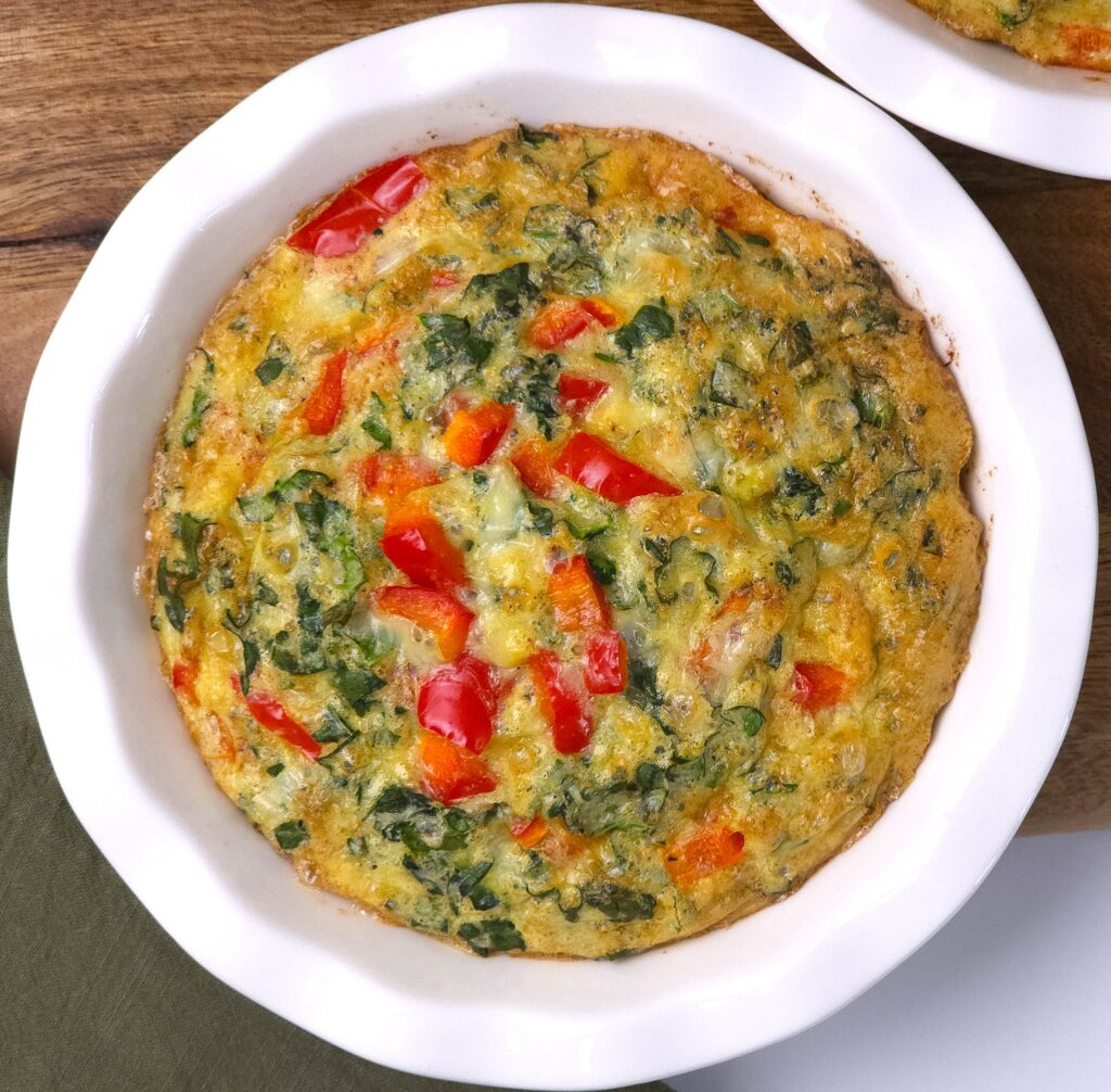 a mini quiche in a white ceramic baking dish