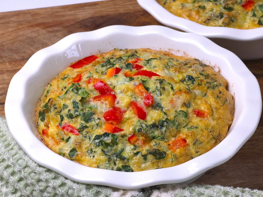 a mini quiche in a white ceramic baking dish