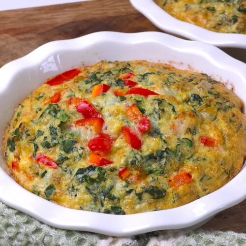 a mini quiche in a white ceramic baking dish
