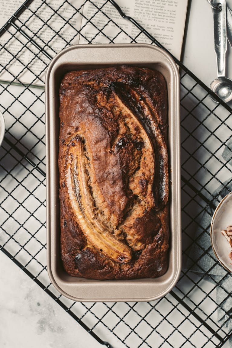 Top view of a delicious homemade banana bread fresh from the oven placed on a cooling rack. Enjoy the warm and inviting aroma.