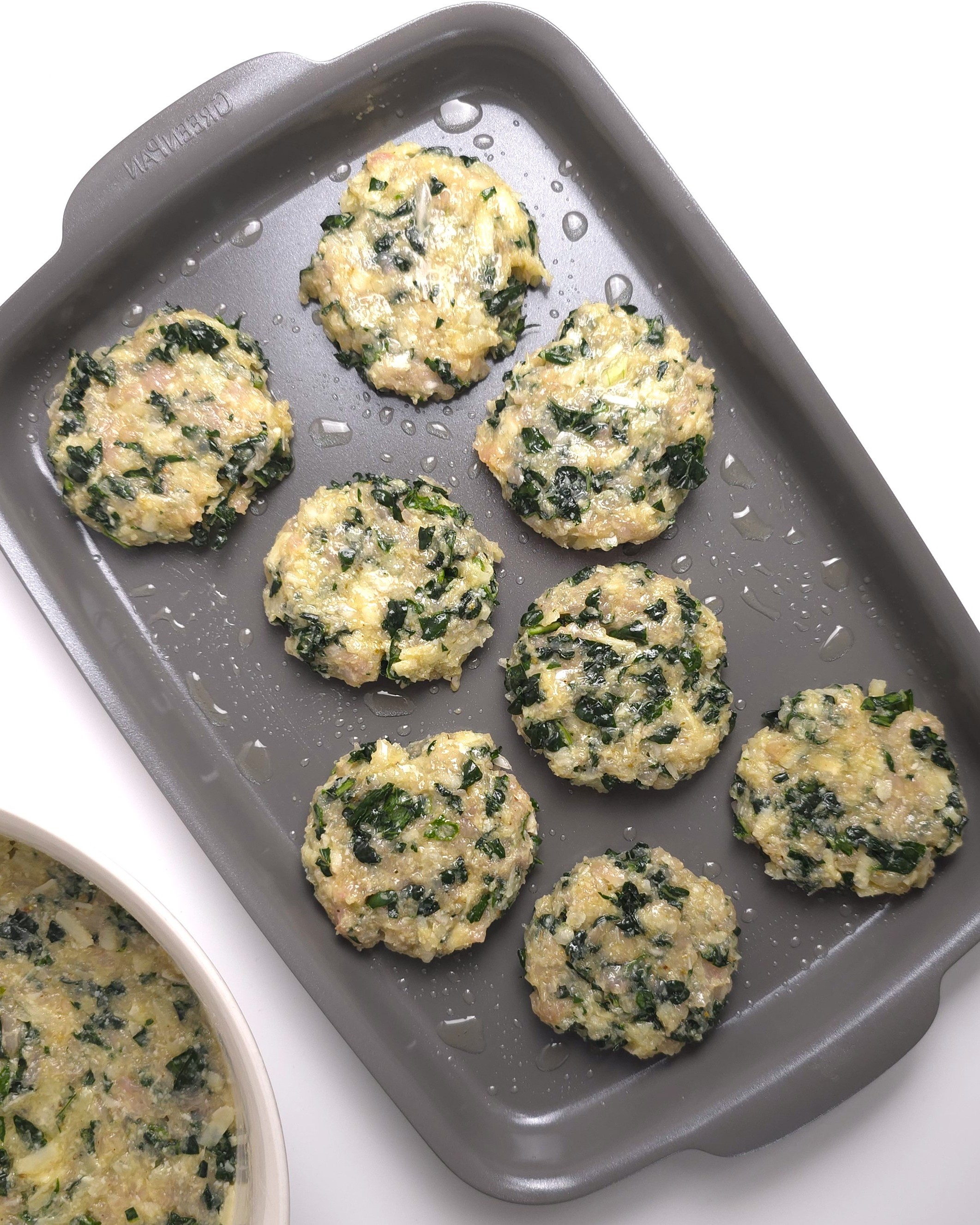 unbaked turkey kale burgers in a grey roasting tray