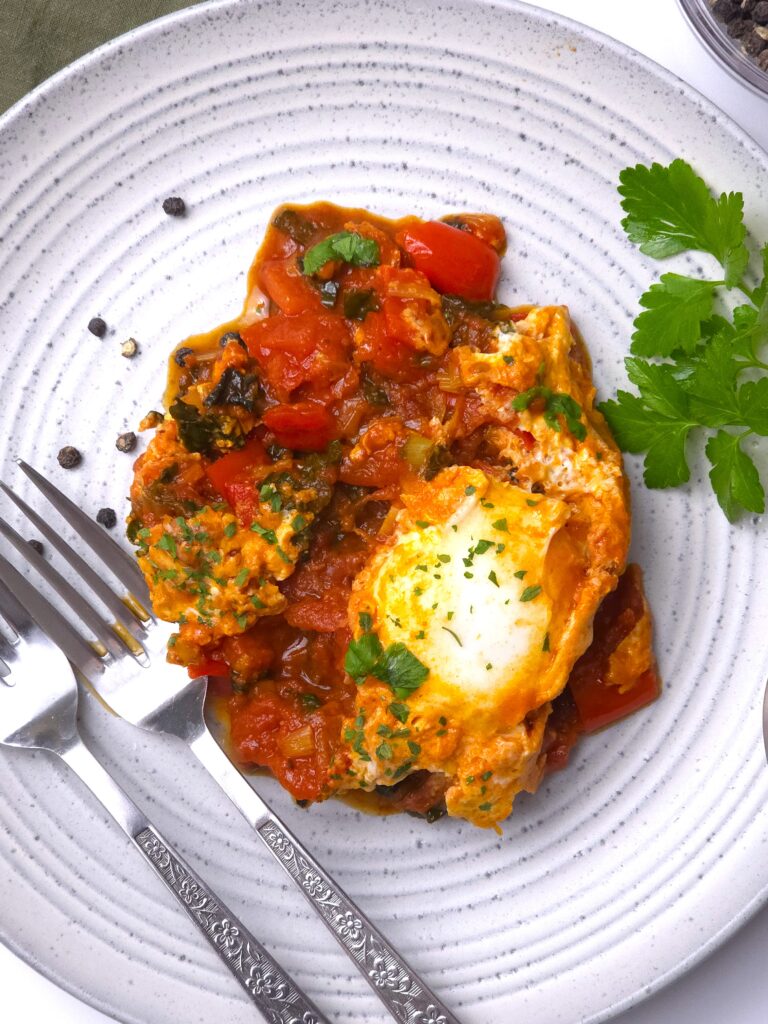 a close look of a grey stoneware plate with vibrant shakshuka recipe