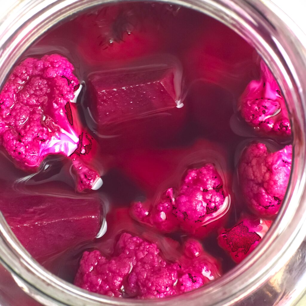 a close look of open jar with fermented vibrant beetroot and cauliflower recipe