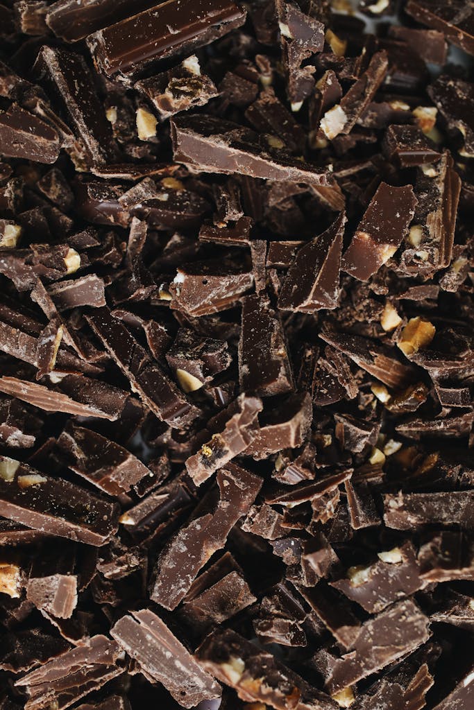 A detailed view of broken chocolate pieces with cocoa health benefits, showcasing texture and indulgence.