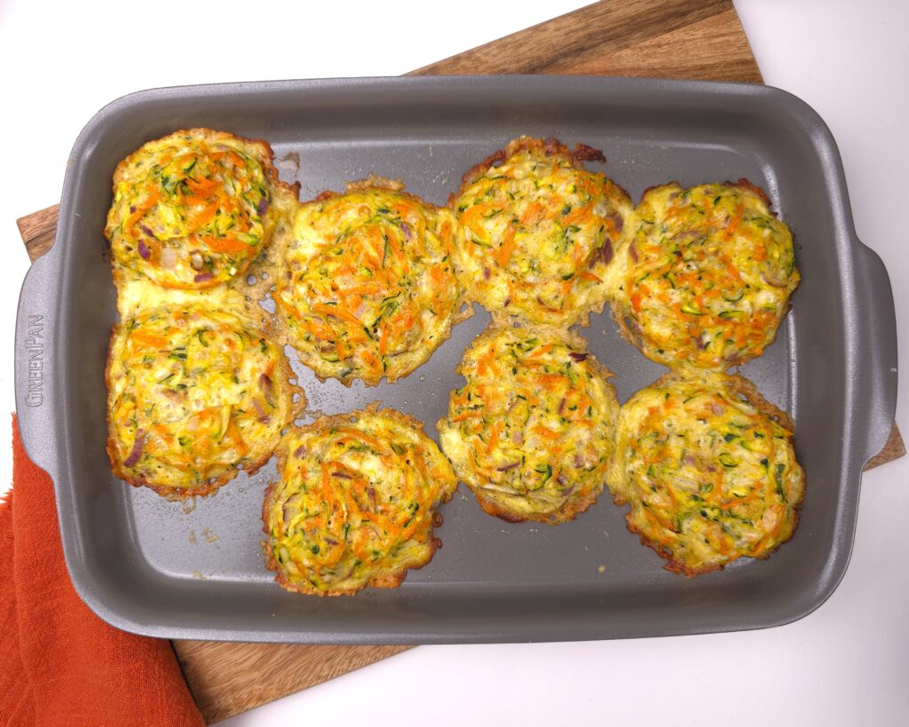 Golden-brown zucchini parmesan fritters on tray