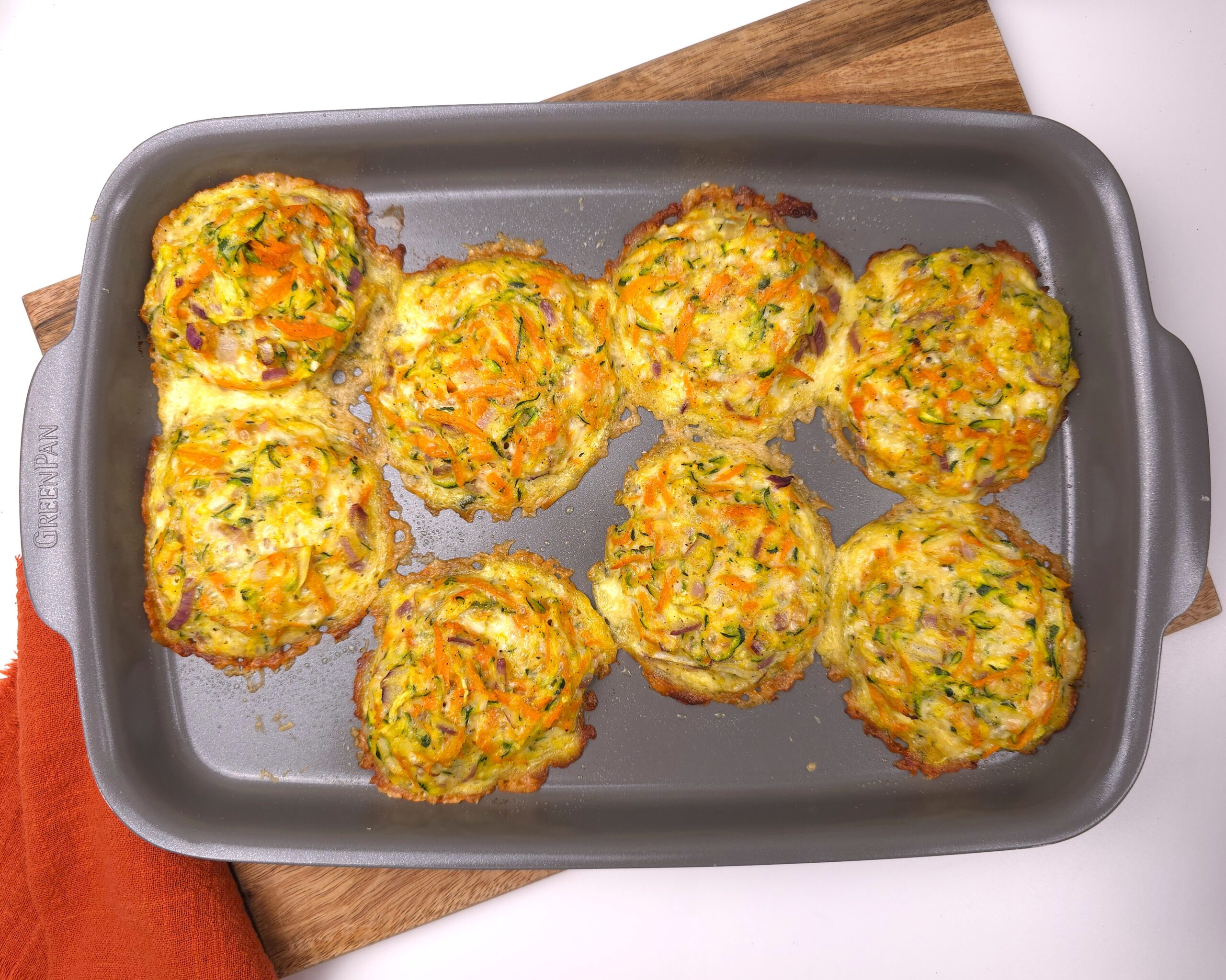 Golden-brown zucchini parmesan fritters on tray