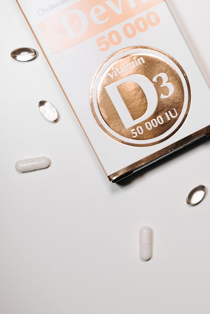 Close-up of vitamin D3 capsules and box on a clean white surface.