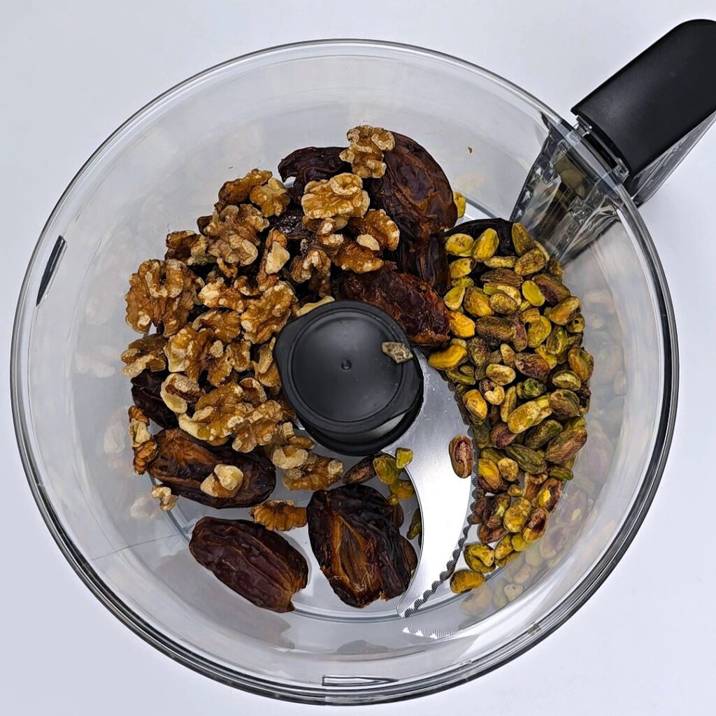 pistachio walnut energy balls ingredients in a blending food processor bowl