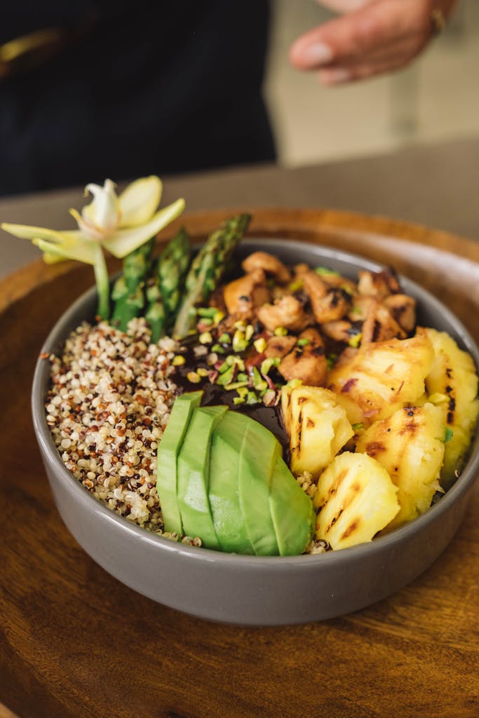 Healthy and colorful Buddha bowl with quinoa, avocado, asparagus, and pineapple.