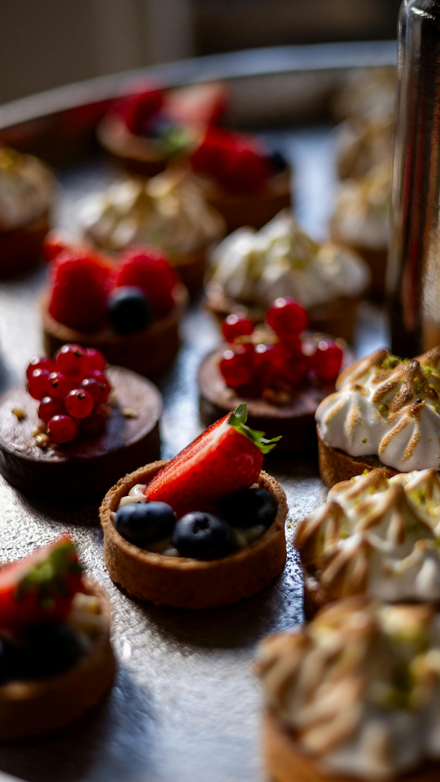 Close-up of assorted mini tartlets topped with fresh berries and meringue part of gluten-free recipes and guides