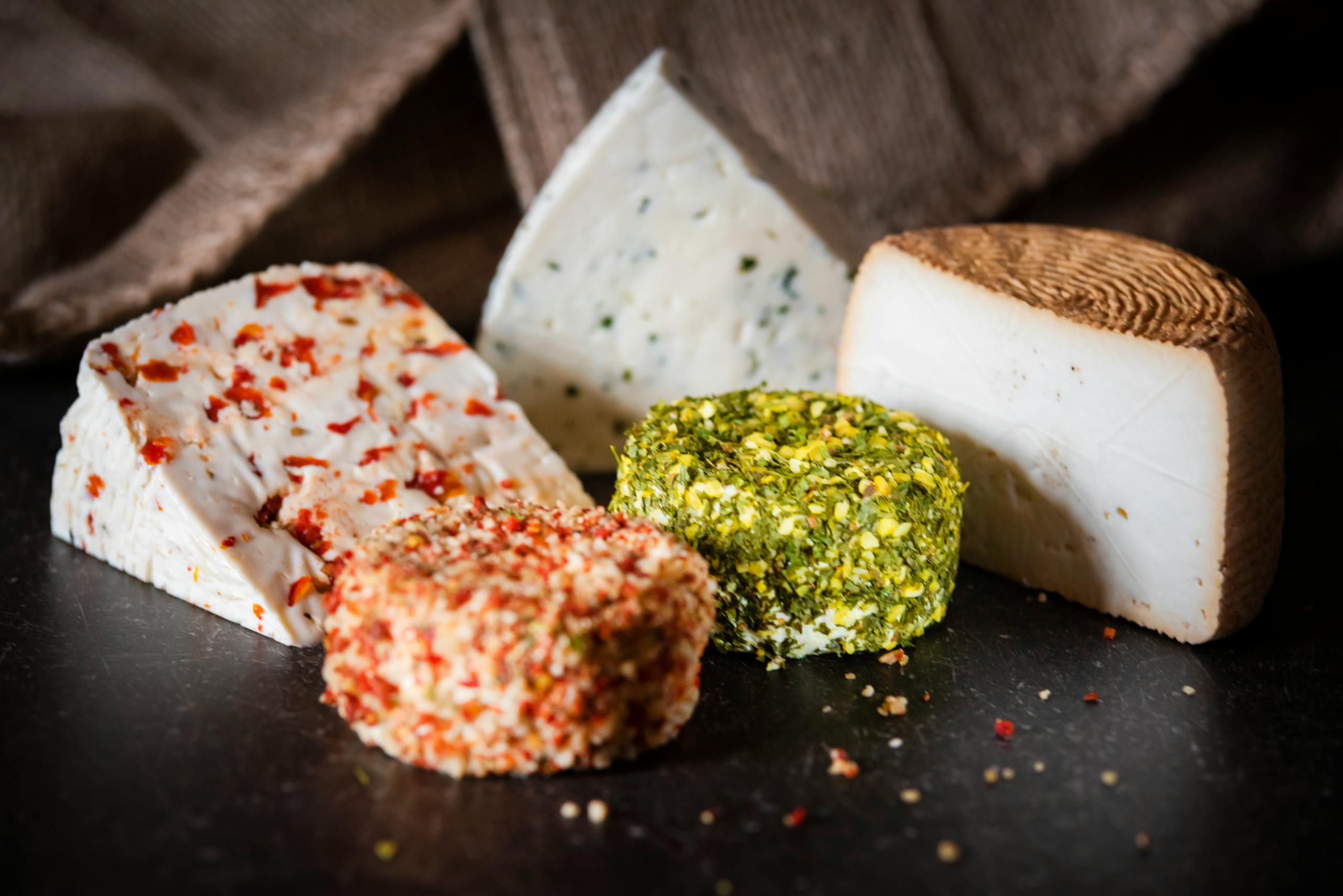 Dairy and gut health - Composition of different kinds of cheese arranged on black surface in light room
